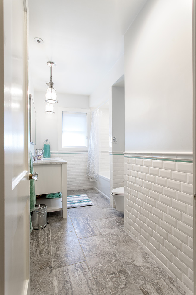Exemple d'une salle de bain principale nature en bois brun avec WC suspendus, un placard à porte affleurante, une baignoire en alcôve, un combiné douche/baignoire, un carrelage blanc, un carrelage métro, un mur blanc, un sol en marbre, un lavabo intégré et un plan de toilette en marbre.