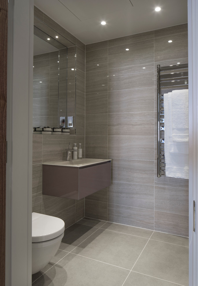 This is an example of a small contemporary bathroom in London with an integrated sink, grey cabinets, glass worktops, grey tiles, ceramic tiles, grey walls, ceramic flooring and flat-panel cabinets.