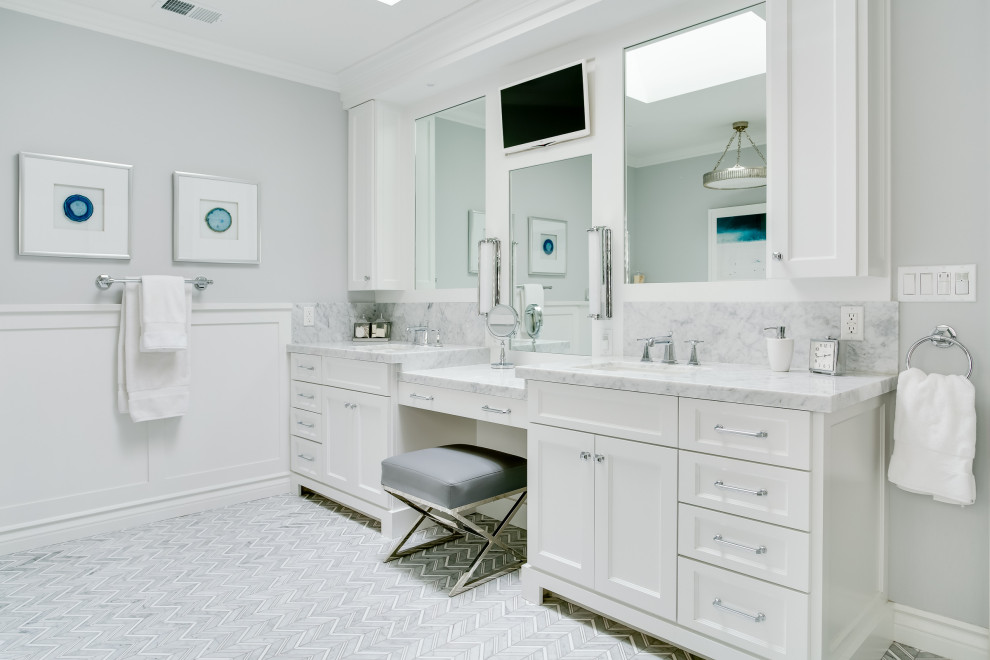 Пример оригинального дизайна: ванная комната в классическом стиле с фасадами с утопленной филенкой, белыми фасадами, серыми стенами, врезной раковиной, серым полом, белой столешницей, тумбой под две раковины, встроенной тумбой и панелями на стенах