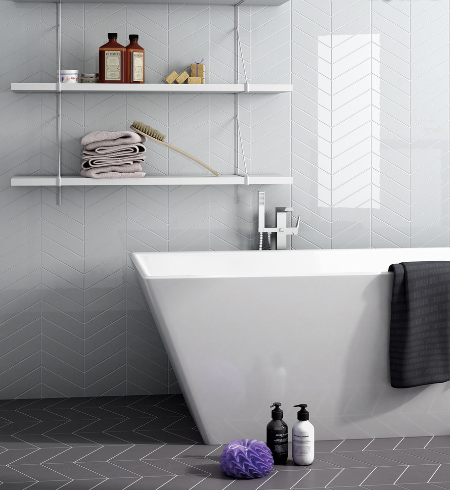 Idée de décoration pour une grande salle de bain principale design avec une baignoire indépendante, un carrelage blanc, des carreaux de céramique, un mur blanc, un sol en carrelage de porcelaine et un sol gris.
