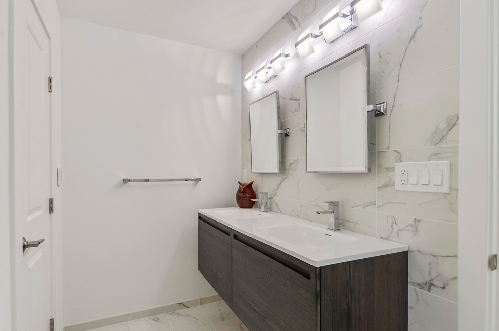 Imagen de cuarto de baño actual de tamaño medio con armarios con paneles lisos, puertas de armario blancas, ducha empotrada, paredes blancas, suelo de madera clara, aseo y ducha, lavabo integrado y encimera de cuarzo compacto