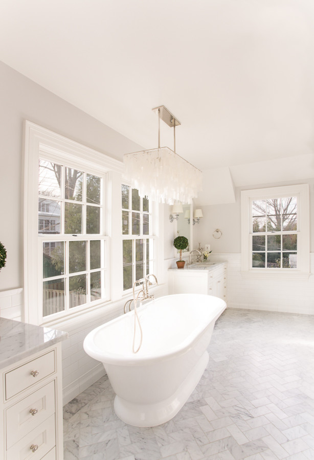 Inspiration for a medium sized classic bathroom in DC Metro with a freestanding bath, beaded cabinets, marble worktops, a submerged sink, white cabinets, stone tiles, white walls and marble flooring.