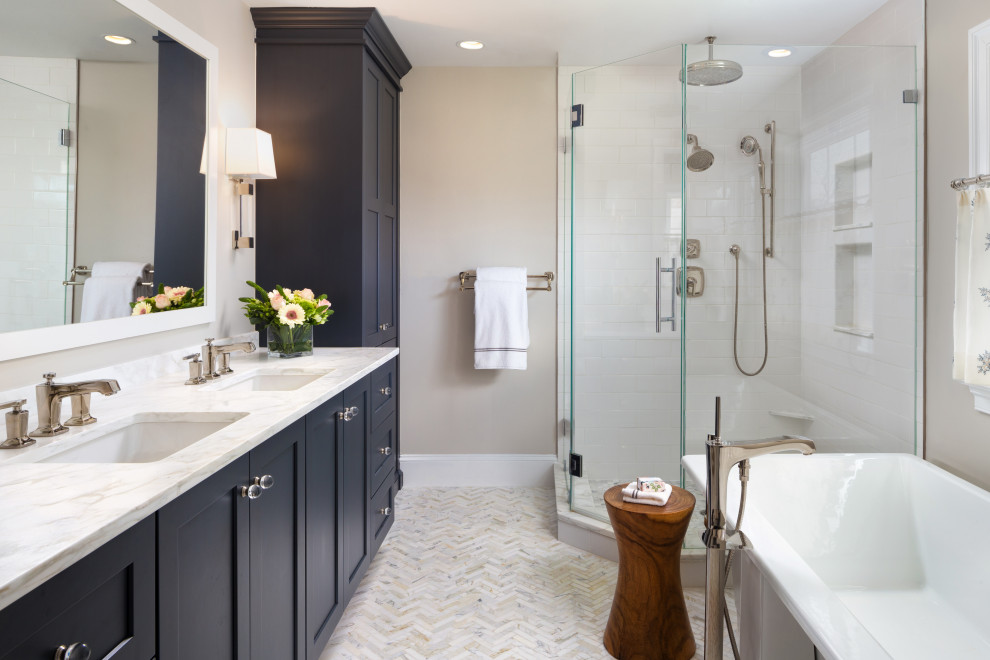 This is an example of a classic ensuite bathroom in DC Metro with shaker cabinets, a corner shower, white tiles, metro tiles, grey walls, a submerged sink, a hinged door, white worktops and double sinks.