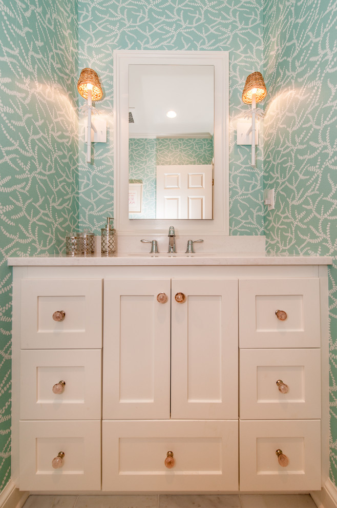 Bild på ett litet maritimt badrum för barn, med ett undermonterad handfat, luckor med infälld panel, vita skåp, granitbänkskiva, en hörndusch, en toalettstol med hel cisternkåpa, grön kakel, gröna väggar och marmorgolv