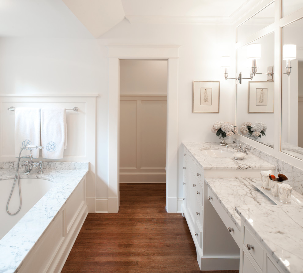 ワシントンD.C.にある高級な広いトラディショナルスタイルのおしゃれなマスターバスルーム (フラットパネル扉のキャビネット、白いキャビネット、アルコーブ型浴槽、白い壁、無垢フローリング、アンダーカウンター洗面器、大理石の洗面台) の写真