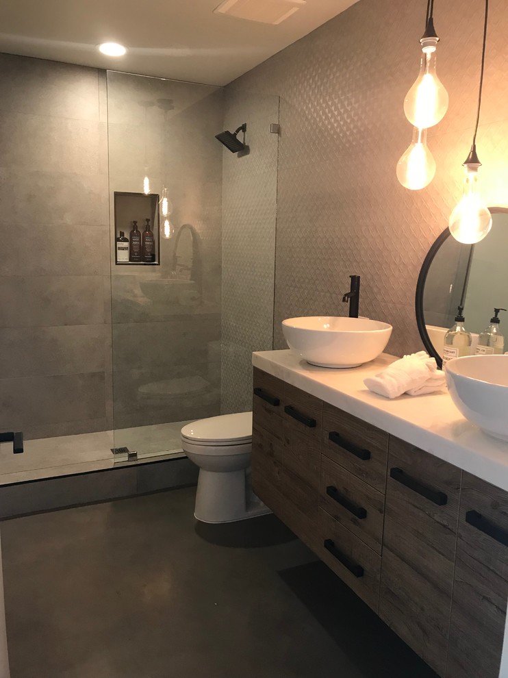Foto di una stanza da bagno minimalista con ante lisce, ante in legno scuro, pareti grigie, pavimento in cemento, top in granito e pavimento grigio