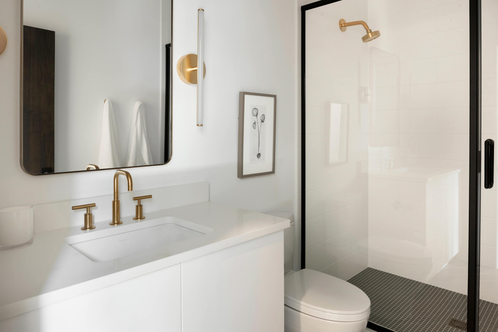 Modelo de cuarto de baño moderno de tamaño medio con puertas de armario blancas, baldosas y/o azulejos blancos, paredes blancas, suelo negro y encimeras blancas