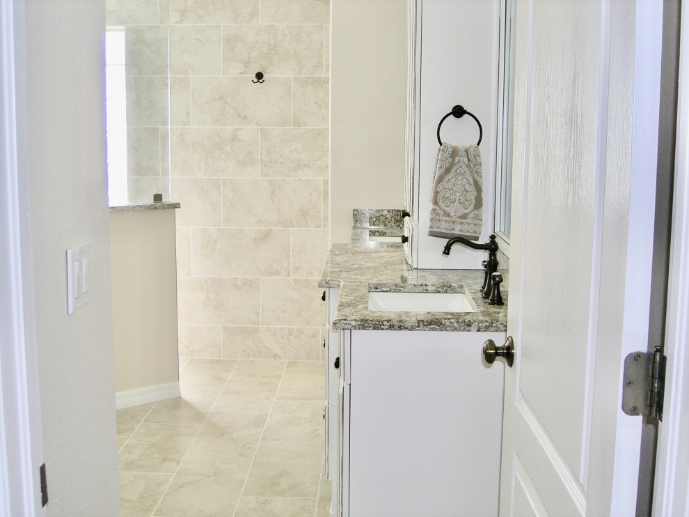 Klassisk inredning av ett mellanstort beige beige en-suite badrum, med luckor med upphöjd panel, vita skåp, en kantlös dusch, en toalettstol med separat cisternkåpa, beige kakel, porslinskakel, beige väggar, klinkergolv i porslin, ett undermonterad handfat, granitbänkskiva, beiget golv och med dusch som är öppen