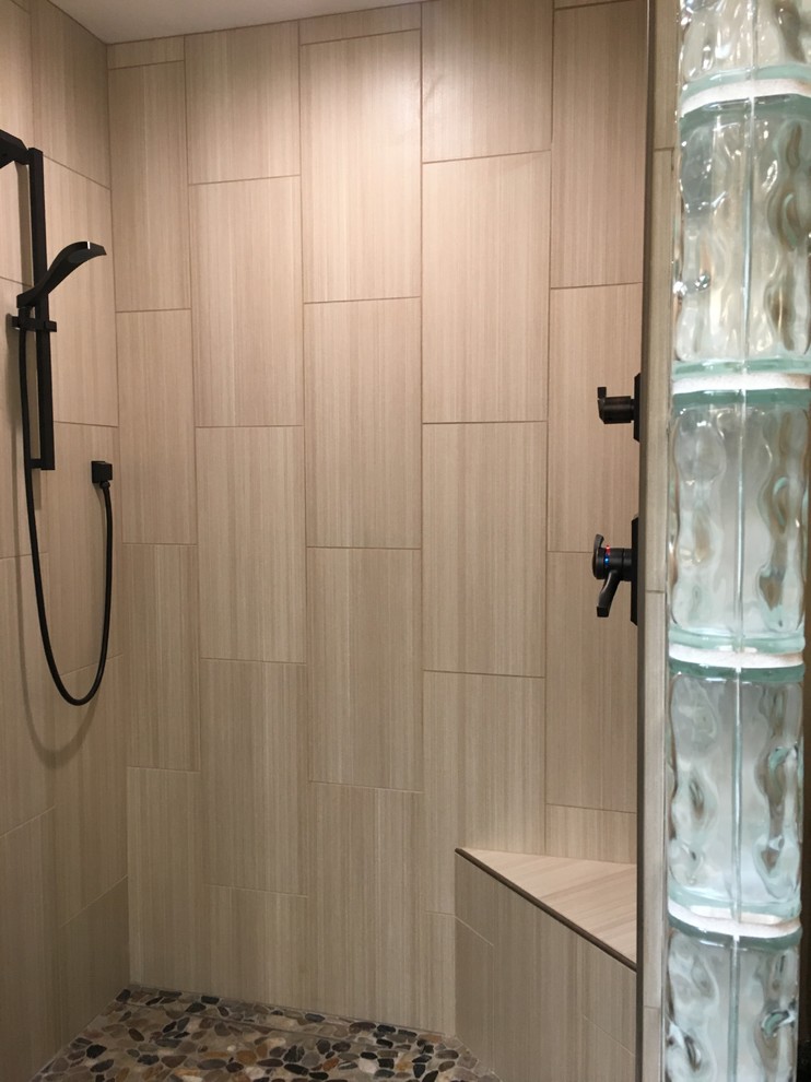Inspiration for a mid-sized contemporary beige tile and pebble tile pebble tile floor walk-in shower remodel in Sacramento with a two-piece toilet, beige walls, medium tone wood cabinets and quartz countertops