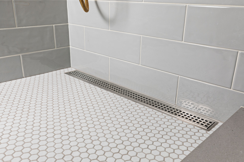 Modelo de cuarto de baño principal ecléctico de tamaño medio con ducha empotrada, baldosas y/o azulejos grises, paredes blancas, ducha con puerta con bisagras, suelo con mosaicos de baldosas y suelo blanco
