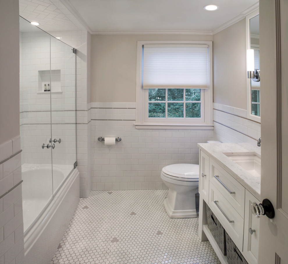 Photo of a large classic family bathroom in New York with shaker cabinets, white cabinets, an alcove bath, an alcove shower, a one-piece toilet, white tiles, metro tiles, grey walls, ceramic flooring, a submerged sink, marble worktops, multi-coloured floors, a hinged door and multi-coloured worktops.
