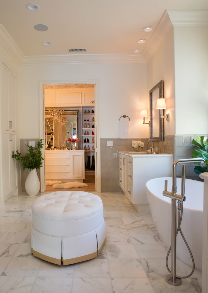 Inspiration for a large mediterranean ensuite bathroom in San Diego with shaker cabinets, white cabinets, a freestanding bath, grey tiles, glass tiles, white walls, marble flooring, a submerged sink and marble worktops.