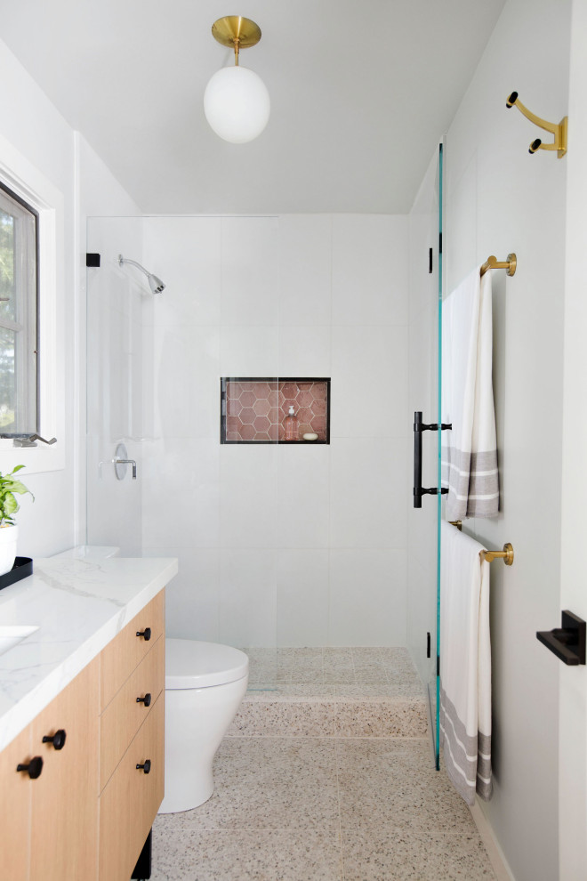 Idéer för att renovera ett mellanstort funkis vit vitt badrum med dusch, med släta luckor, skåp i ljust trä, en dusch i en alkov, en toalettstol med separat cisternkåpa, vit kakel, porslinskakel, grå väggar, terrazzogolv, ett undermonterad handfat, bänkskiva i kvarts, vitt golv och dusch med gångjärnsdörr