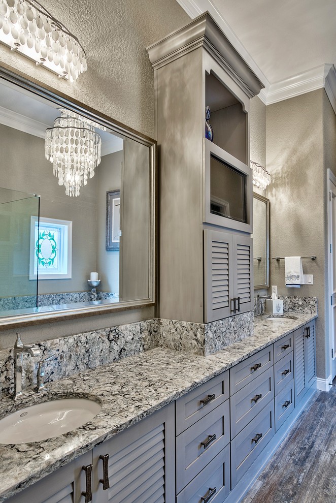 Пример оригинального дизайна: большая главная ванная комната в стиле шебби-шик с фасадами с филенкой типа жалюзи, серыми фасадами, полновстраиваемой ванной, открытым душем, серой плиткой, керамогранитной плиткой, серыми стенами, полом из керамогранита, врезной раковиной и столешницей из искусственного кварца
