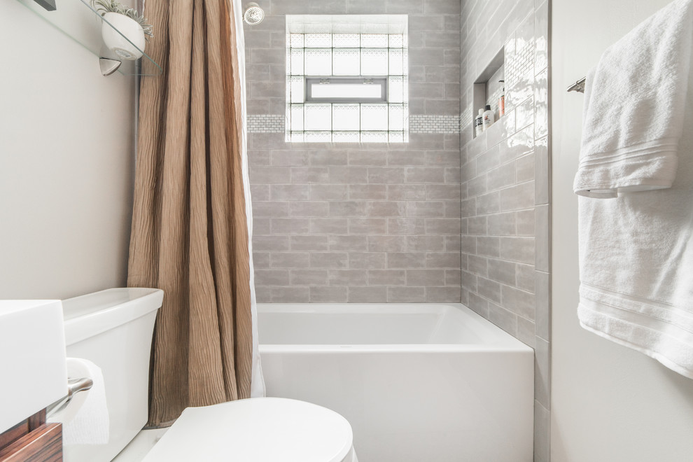 Aménagement d'une salle de bain principale contemporaine de taille moyenne avec une baignoire d'angle, un combiné douche/baignoire, WC à poser, un carrelage gris, des carreaux de céramique, un mur gris, un sol en carrelage de terre cuite, un lavabo posé et une cabine de douche avec un rideau.