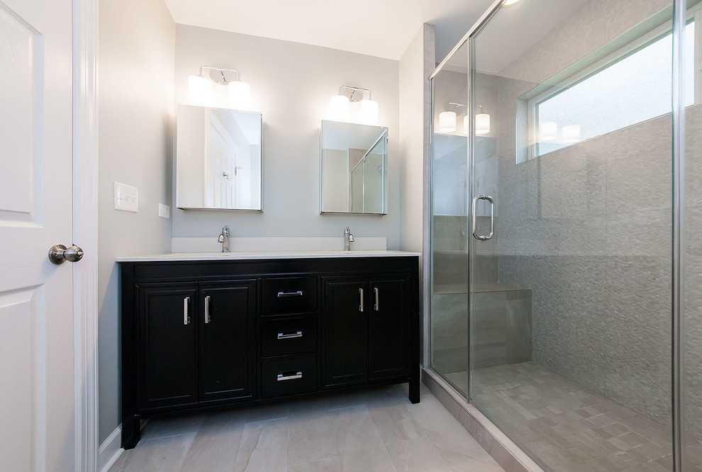 Inredning av ett klassiskt mellanstort badrum med dusch, med luckor med upphöjd panel, svarta skåp, en dubbeldusch, beige kakel, keramikplattor, beige väggar, travertin golv, ett undermonterad handfat, marmorbänkskiva, beiget golv och dusch med gångjärnsdörr