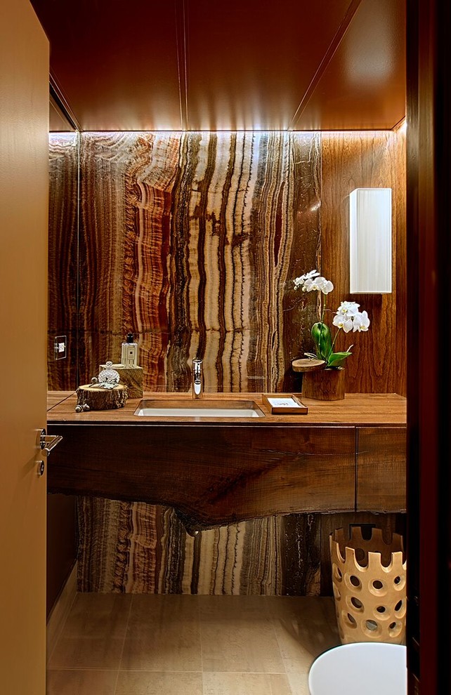 Inspiration for a medium sized classic shower room bathroom in Chicago with flat-panel cabinets, dark wood cabinets, brown walls, a submerged sink, beige tiles, stone tiles, limestone flooring, wooden worktops and brown worktops.