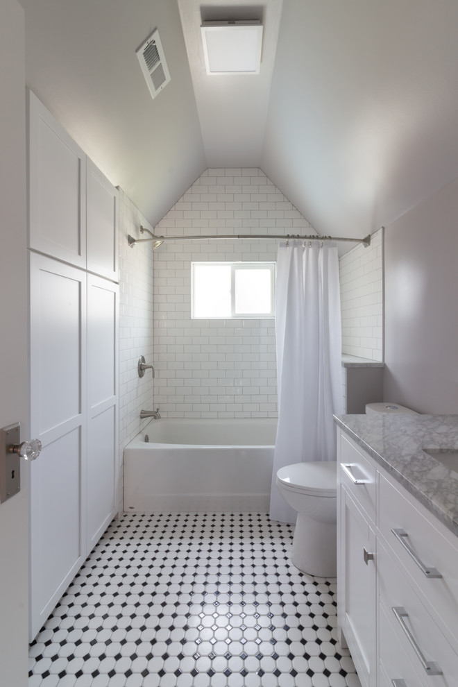 Aménagement d'une salle de bain classique avec des portes de placard blanches, une baignoire en alcôve, un combiné douche/baignoire, un carrelage blanc, un mur gris, un sol en carrelage de porcelaine, un sol multicolore, une cabine de douche avec un rideau et un plan de toilette gris.