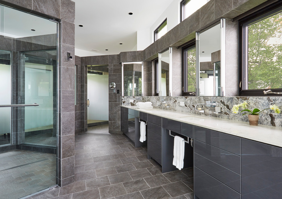 Example of a trendy master gray tile gray floor walk-in shower design in Chicago with flat-panel cabinets, gray cabinets, an undermount sink and white countertops