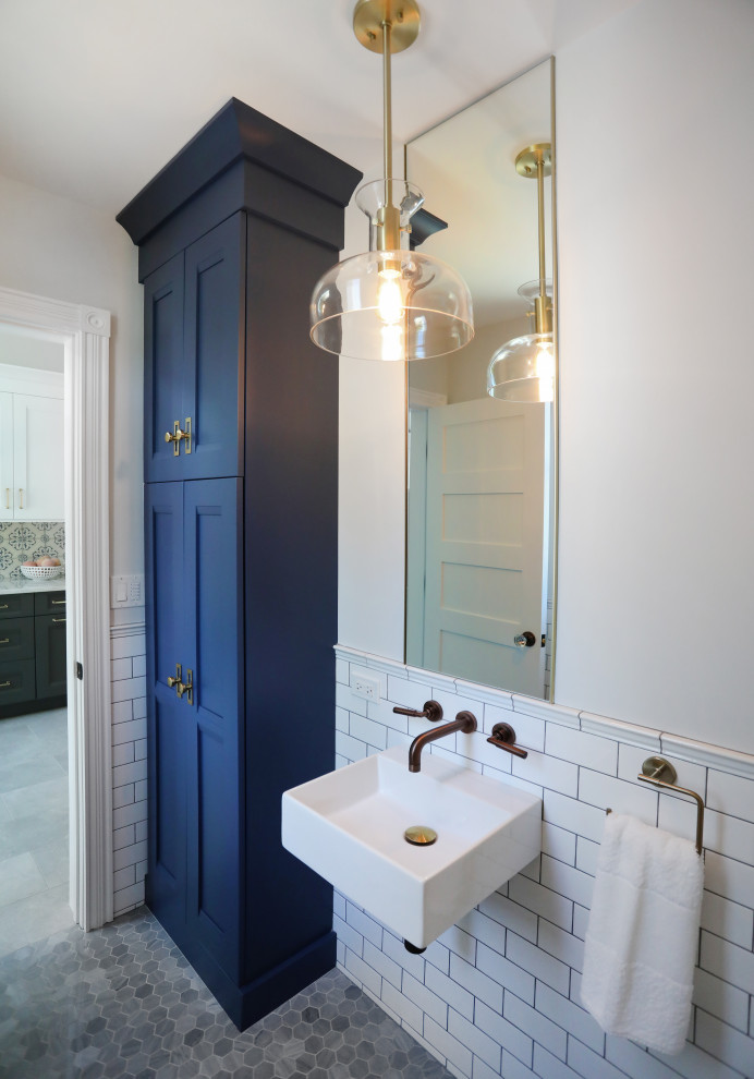 Exempel på ett mellanstort 50 tals badrum, med luckor med infälld panel, blå skåp, vit kakel, keramikplattor, grå väggar, marmorgolv, ett väggmonterat handfat och grått golv