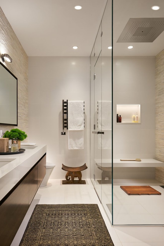 Design ideas for a large contemporary ensuite bathroom in Chicago with flat-panel cabinets, solid surface worktops, a built-in shower, beige tiles, matchstick tiles, porcelain flooring, a submerged sink, white floors, a hinged door, dark wood cabinets, white worktops, a wall niche and a shower bench.