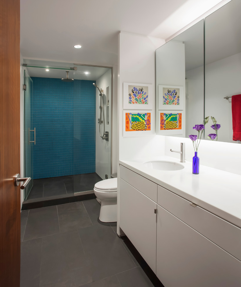 Diseño de cuarto de baño principal contemporáneo de tamaño medio con armarios con paneles lisos, puertas de armario blancas, encimera de acrílico, baldosas y/o azulejos azules, baldosas y/o azulejos de vidrio, paredes blancas y suelo de baldosas de porcelana