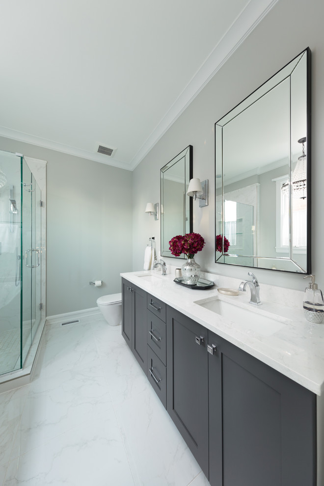 Medium sized contemporary ensuite wet room bathroom in Chicago with raised-panel cabinets, grey cabinets, a freestanding bath, a two-piece toilet, white tiles, mosaic tiles, beige walls, mosaic tile flooring, a submerged sink, engineered stone worktops, white floors and a sliding door.