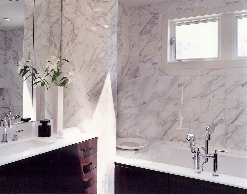 Exemple d'un grand sauna tendance en bois foncé avec un lavabo encastré, un placard à porte plane, un plan de toilette en marbre, une baignoire encastrée, WC à poser, un carrelage blanc, un carrelage de pierre et un sol en marbre.