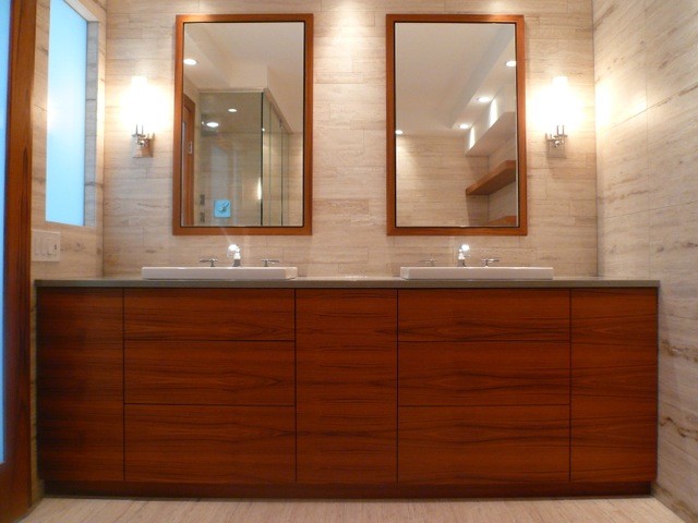 Пример оригинального дизайна: большая главная ванная комната в стиле модернизм с плоскими фасадами, фасадами цвета дерева среднего тона, столешницей из известняка, бежевой плиткой, каменной плиткой и полом из известняка