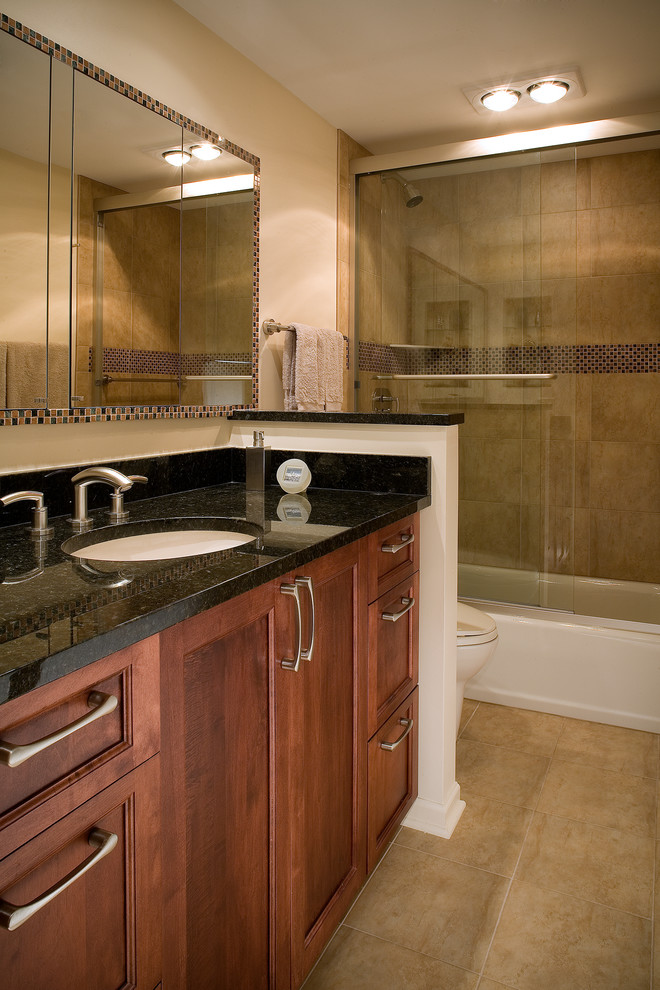 Idéer för ett mellanstort klassiskt en-suite badrum, med ett undermonterad handfat, skåp i mörkt trä, granitbänkskiva, en dusch/badkar-kombination, en toalettstol med hel cisternkåpa, beige kakel och beige väggar