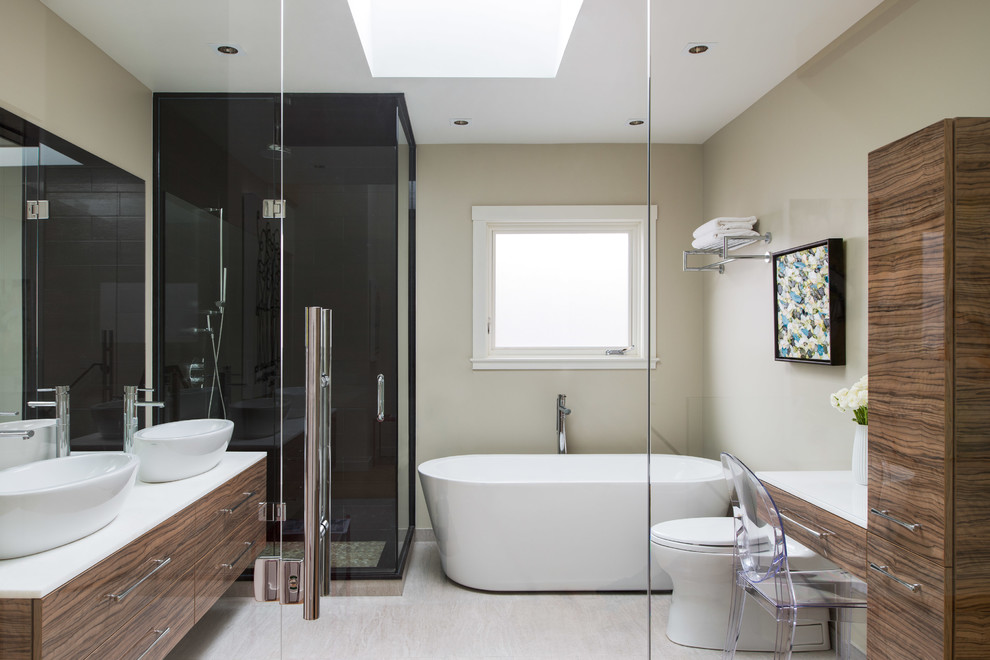 Modernes Badezimmer mit Aufsatzwaschbecken, flächenbündigen Schrankfronten, dunklen Holzschränken, freistehender Badewanne, Eckdusche und beiger Wandfarbe in Toronto
