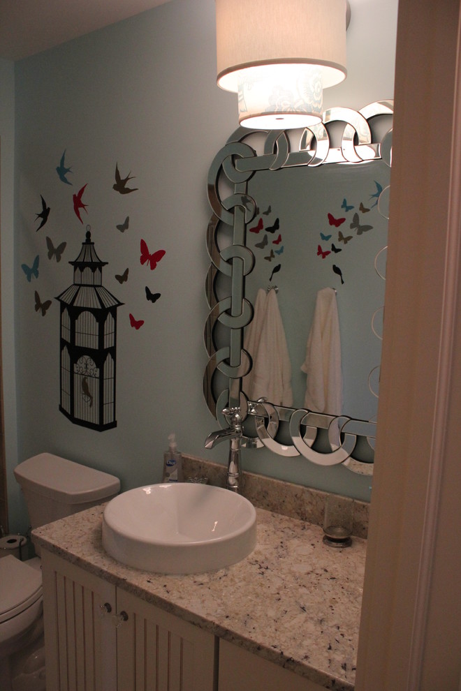 Cette image montre une salle de bain marine avec des portes de placard blanches, une vasque et un plan de toilette en granite.