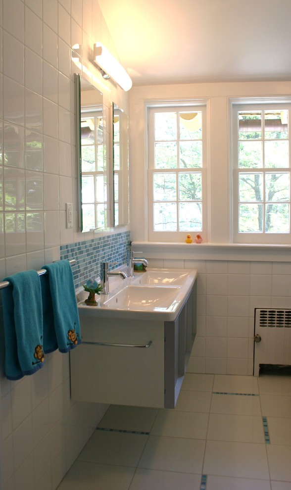 Kleines Modernes Badezimmer mit integriertem Waschbecken, grauen Schränken, Duschbadewanne, Terrazzo-Boden, Mineralwerkstoff-Waschtisch, blauen Fliesen, Glasfliesen und weißer Wandfarbe in New York