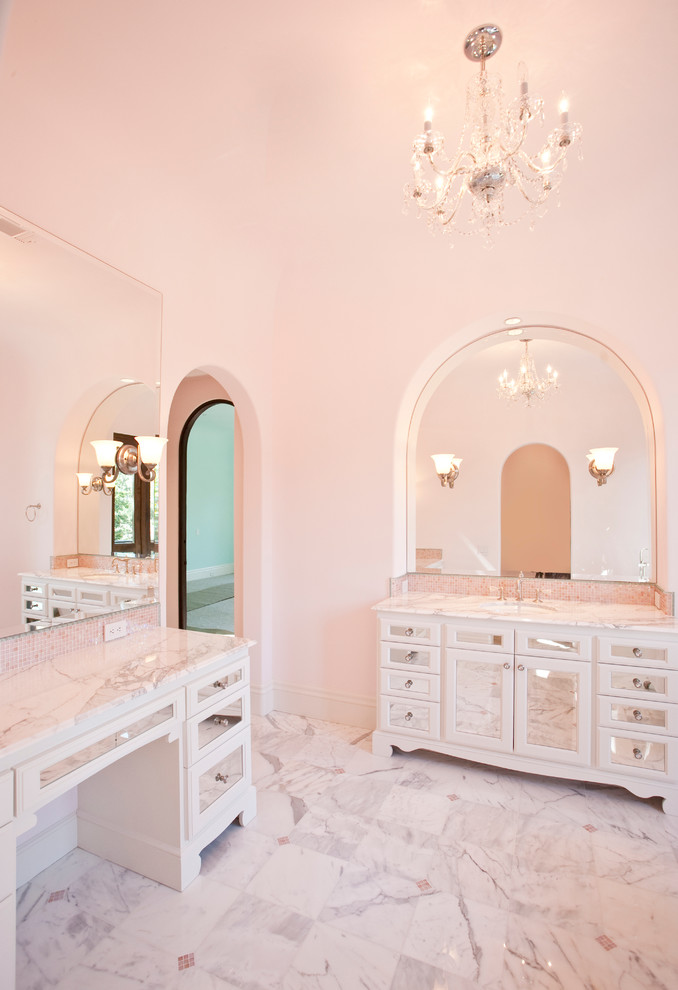 Klassisk inredning av ett mycket stort badrum för barn, med ett undermonterad handfat, luckor med glaspanel, marmorbänkskiva, ett badkar med tassar, en dusch/badkar-kombination, rosa kakel, mosaik, rosa väggar, marmorgolv och vita skåp