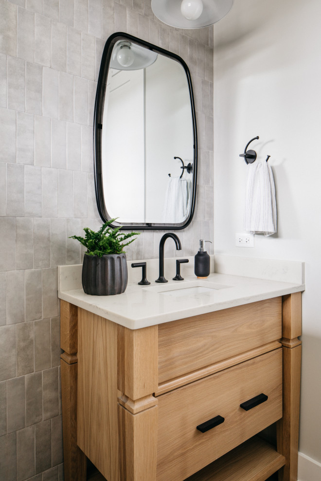 Idées déco pour une salle de bain classique en bois clair avec un placard à porte plane, un carrelage gris, un mur blanc, un lavabo encastré, un plan de toilette blanc, meuble simple vasque et meuble-lavabo encastré.