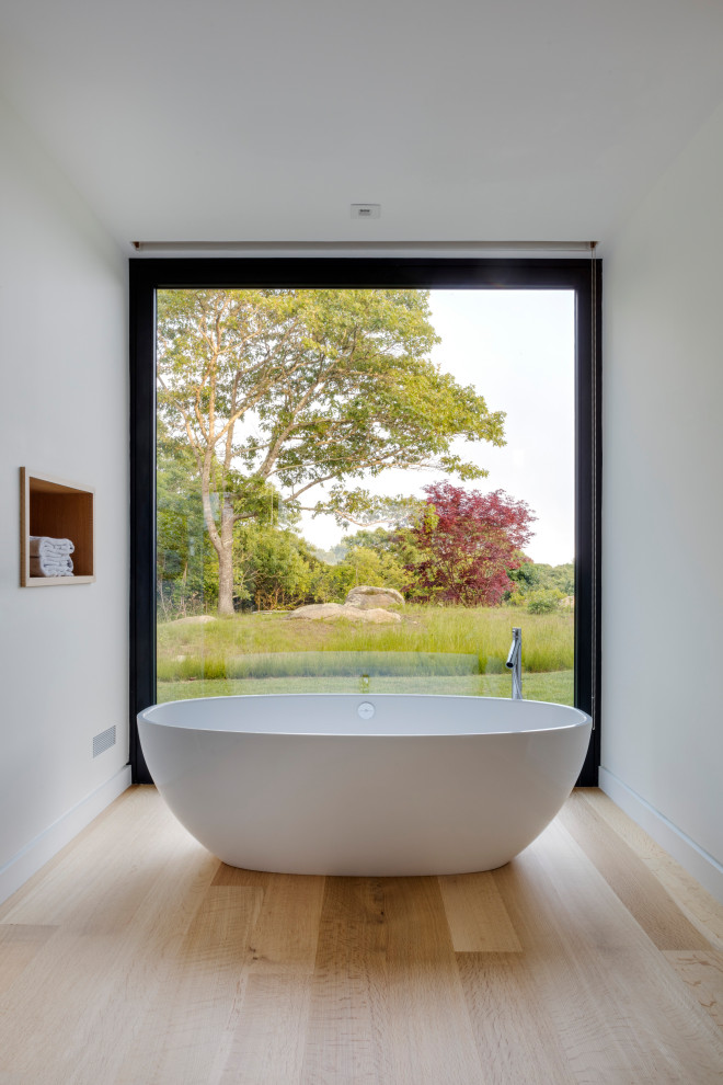 Inspiration för ett stort funkis en-suite badrum, med ett fristående badkar, vita väggar, mellanmörkt trägolv och beiget golv