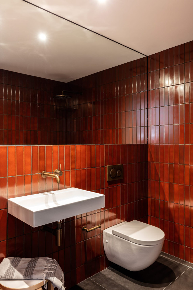 シドニーにあるコンテンポラリースタイルのおしゃれな浴室 (壁掛け式トイレ、赤いタイル、壁付け型シンク、グレーの床、洗面台1つ) の写真