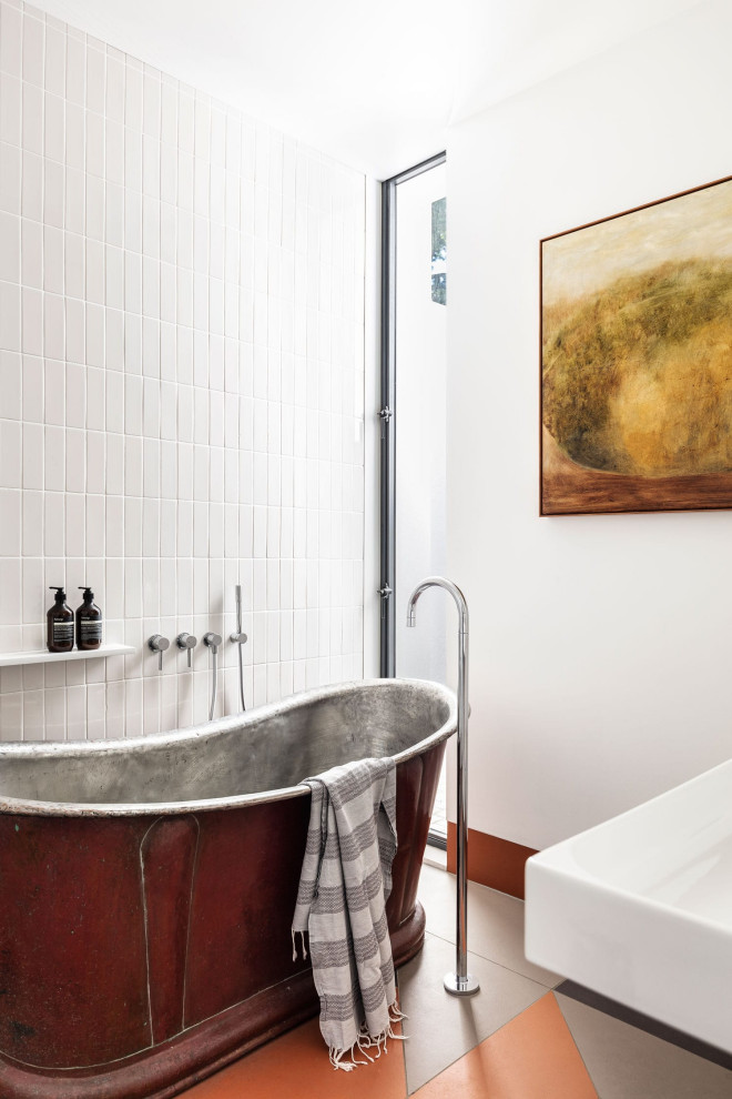 Immagine di una stanza da bagno design con vasca freestanding, piastrelle bianche, pareti bianche e pavimento multicolore