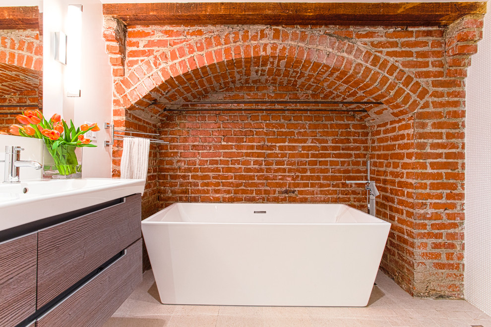 Стильный дизайн: главная ванная комната в современном стиле с раковиной с несколькими смесителями, плоскими фасадами, отдельно стоящей ванной и оранжевыми стенами - последний тренд