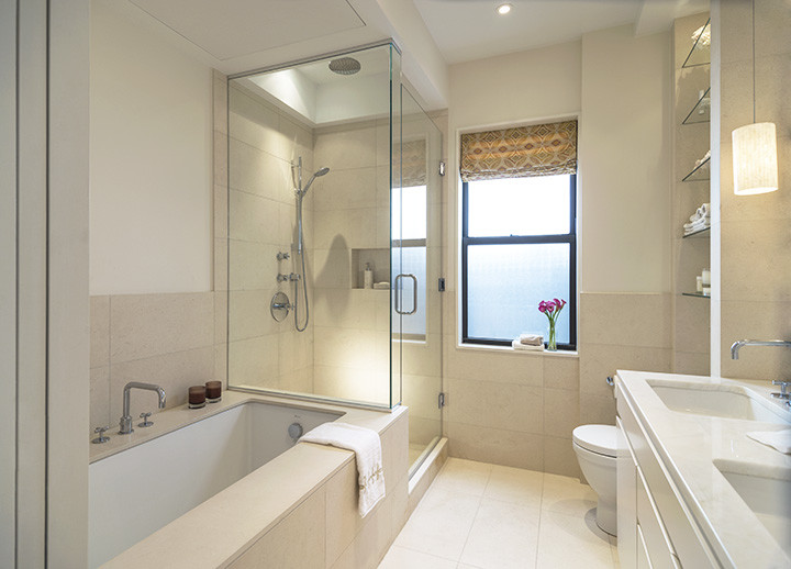 Inredning av ett modernt badrum, med ett undermonterad handfat, ett undermonterat badkar, en hörndusch och en toalettstol med separat cisternkåpa
