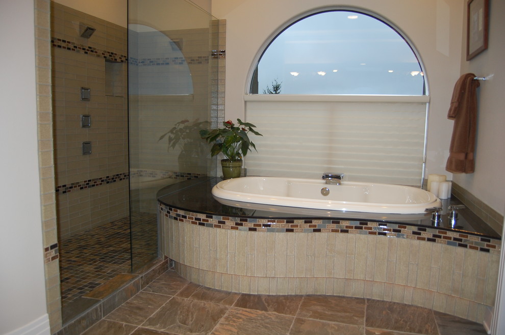 Diseño de cuarto de baño contemporáneo con encimera de granito, bañera encastrada, ducha abierta, sanitario de una pieza, baldosas y/o azulejos beige, baldosas y/o azulejos de vidrio, paredes beige y suelo de baldosas de porcelana
