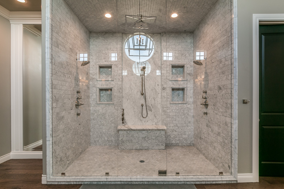 На фото: большая главная ванная комната в стиле неоклассика (современная классика) с фасадами с выступающей филенкой, белыми фасадами, отдельно стоящей ванной, двойным душем, унитазом-моноблоком, белой плиткой, мраморной плиткой, серыми стенами, паркетным полом среднего тона, врезной раковиной, мраморной столешницей, коричневым полом и душем с распашными дверями с