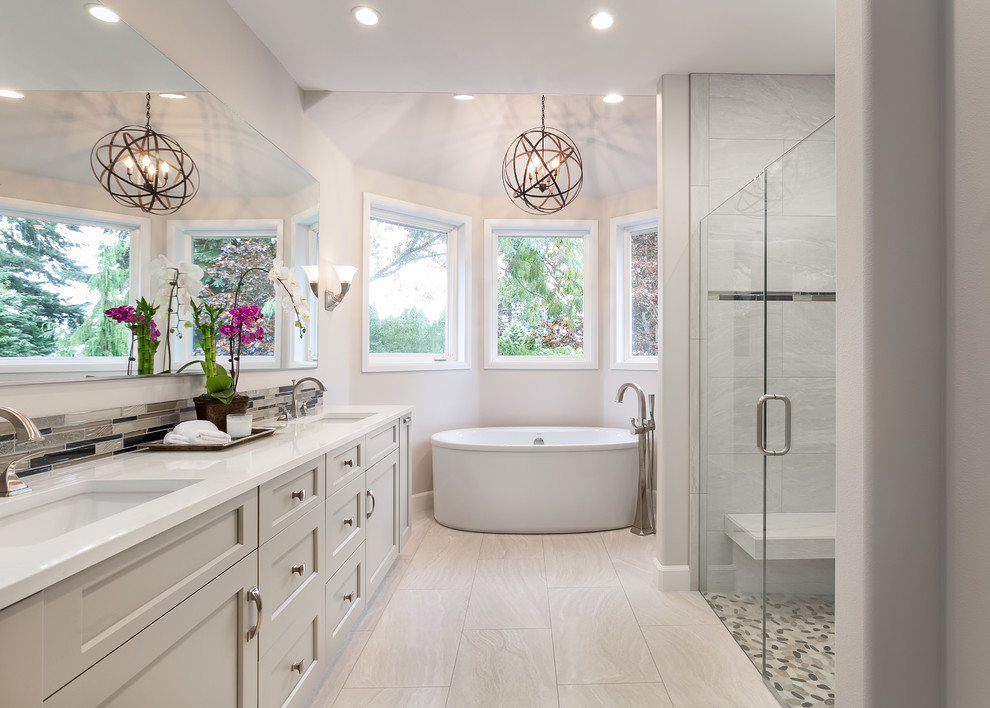 Идея дизайна: ванная комната в стиле неоклассика (современная классика) с серыми фасадами, отдельно стоящей ванной, душем без бортиков, серой плиткой, серыми стенами, врезной раковиной и душем с распашными дверями