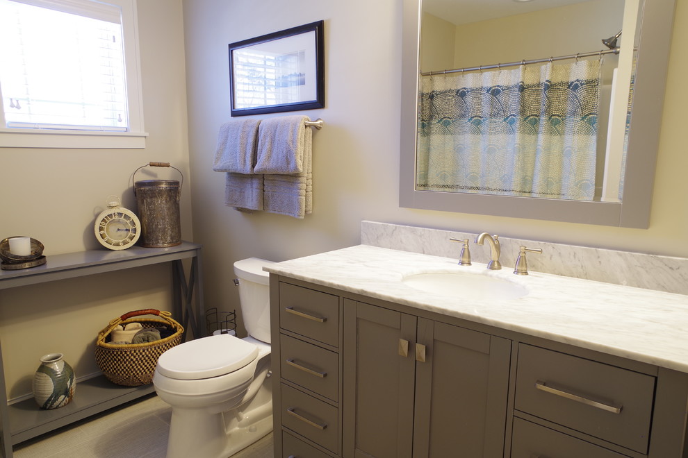 Idéer för mellanstora amerikanska grått badrum med dusch, med skåp i shakerstil, bruna skåp, en dusch/badkar-kombination, en toalettstol med hel cisternkåpa, beige väggar, klinkergolv i porslin, ett integrerad handfat, bänkskiva i kvartsit, beiget golv och dusch med duschdraperi