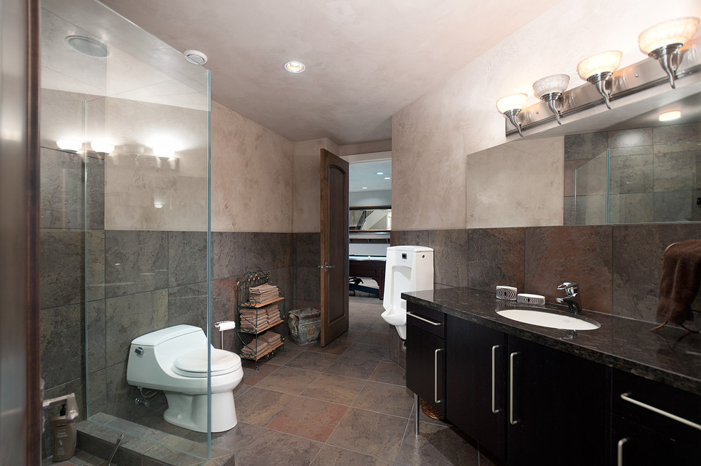 Пример оригинального дизайна: главная ванная комната среднего размера в современном стиле с плоскими фасадами, черными фасадами, душем в нише, унитазом-моноблоком, бежевой плиткой, коричневой плиткой, серой плиткой, каменной плиткой, бежевыми стенами, полом из сланца, врезной раковиной и столешницей из гранита