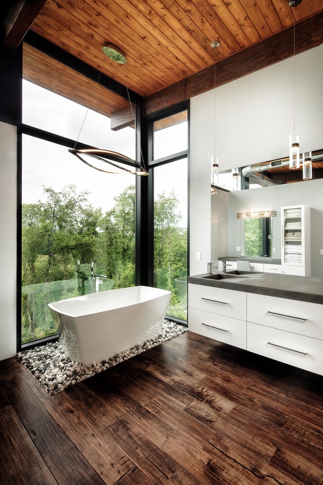 Freestanding bathtub - large modern master white tile dark wood floor and brown floor freestanding bathtub idea in Other with flat-panel cabinets, white cabinets, white walls, an integrated sink and concrete countertops