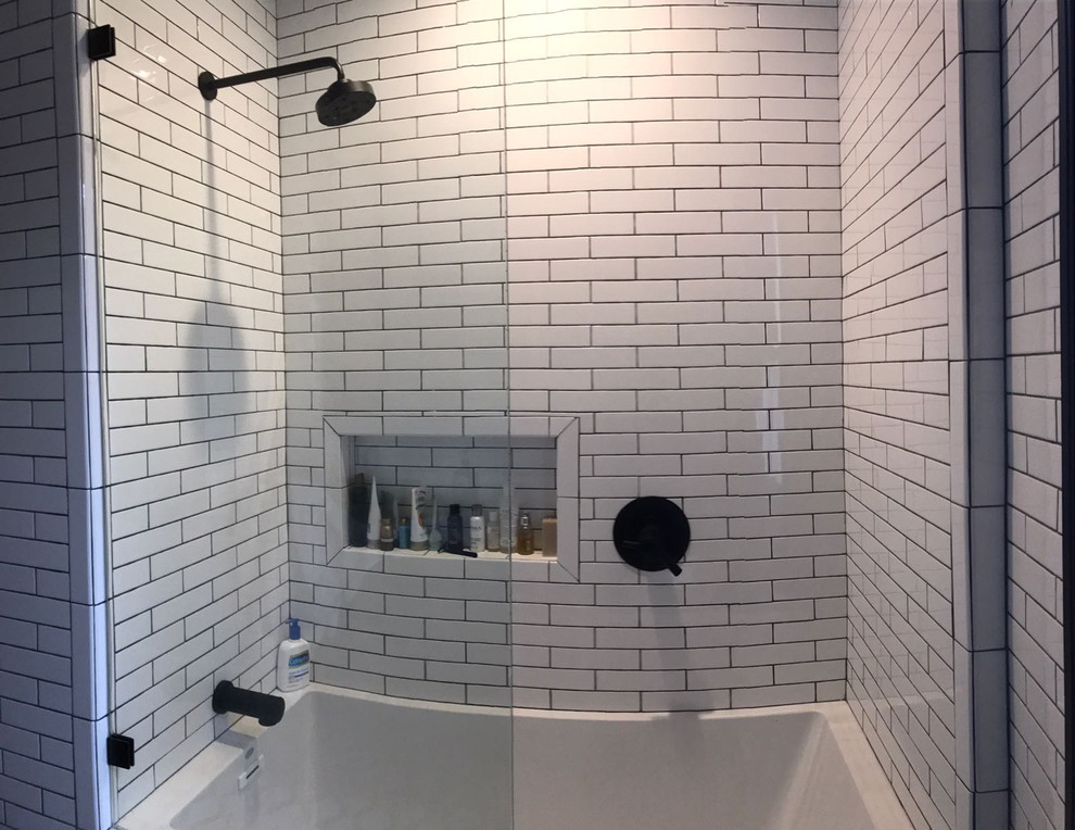 На фото: ванная комната среднего размера в стиле модернизм с фасадами в стиле шейкер, черными фасадами, ванной в нише, душем над ванной, унитазом-моноблоком, белой плиткой, плиткой кабанчик, белыми стенами, мраморным полом, душевой кабиной, врезной раковиной, мраморной столешницей, разноцветным полом, душем с распашными дверями и белой столешницей