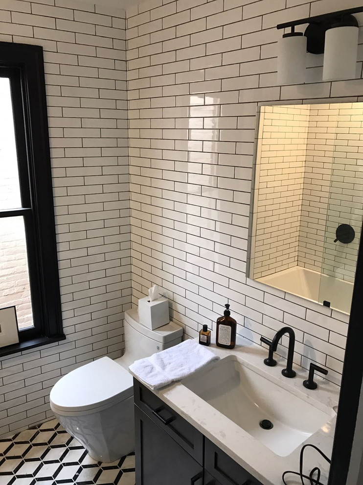 ワシントンD.C.にある高級な中くらいなモダンスタイルのおしゃれなバスルーム (浴槽なし) (シェーカースタイル扉のキャビネット、黒いキャビネット、アルコーブ型浴槽、シャワー付き浴槽	、一体型トイレ	、白いタイル、サブウェイタイル、白い壁、大理石の床、アンダーカウンター洗面器、大理石の洗面台、マルチカラーの床、開き戸のシャワー、白い洗面カウンター) の写真
