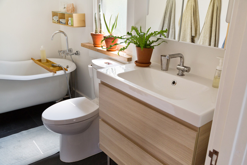 Inspiration for a small transitional 3/4 slate floor and gray floor claw-foot bathtub remodel in Portland with flat-panel cabinets, light wood cabinets, a two-piece toilet, white walls, an integrated sink, solid surface countertops and white countertops