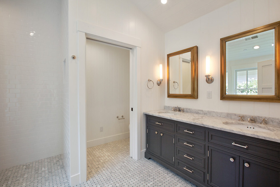 Inredning av ett klassiskt vit vitt badrum, med luckor med profilerade fronter, blå skåp, en öppen dusch, vit kakel, tunnelbanekakel, klinkergolv i keramik, ett undermonterad handfat, bänkskiva i kvartsit, flerfärgat golv och med dusch som är öppen